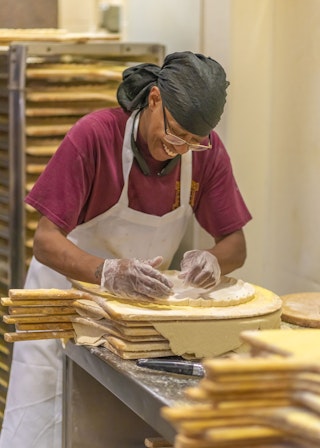 Barnaby's employee working on pizza crust.