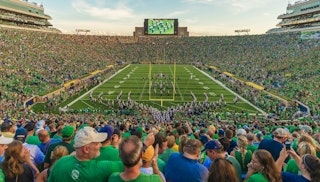 Notre Dame Stadium filled on gameday with the band marching onto the field
