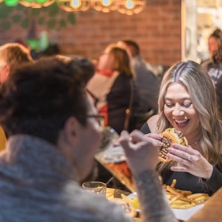 Man and woman enjoy burgers and beer at Howard Park Public House restaurant.