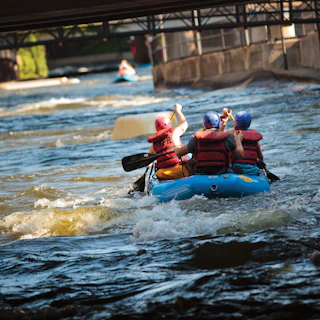 A group of people rafter down the East Race Waterway in the heart of downtown South Bend