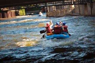 A group of people rafter down the East Race Waterway in the heart of downtown South Bend