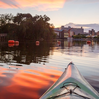 A kayak in the St. Joseph River with the Century Center in the background