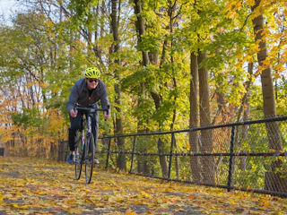 A bicyclist bikes along the East Bank Trail during Autumn