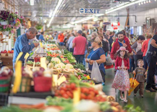 A visitor buys produce at the South Bend Farmers Market on a busy Saturday morning
