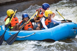 A kayak of four people go down the East Race Waterway in downtown South Bend